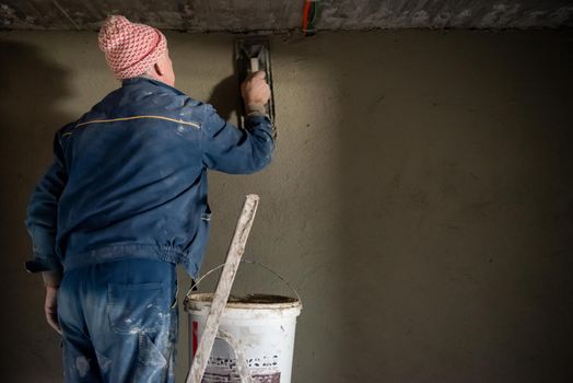 Worker plastering the wall by concrete