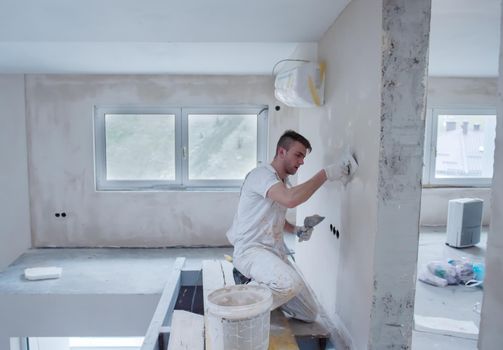 construction worker plastering on gypsum walls