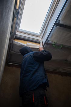 roofer man installing thermal insulation layer