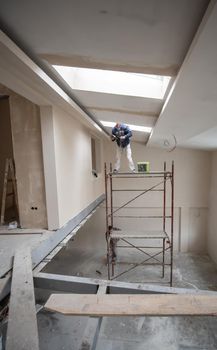 construction worker plastering on gypsum ceiling