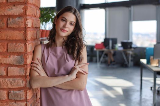 Attractive business woman smiling while standing in the office