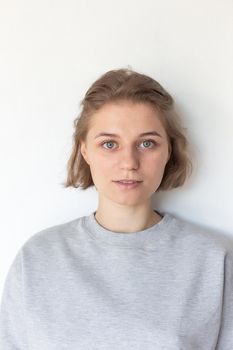 portrait of pretty girl with short hair posing in sweatshirt on white background
