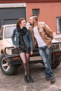 young couple standing near the car in the city Parking lot