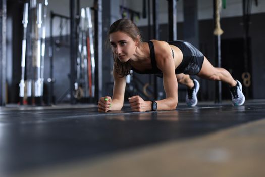 Portrait of a muscular woman on a plank position.