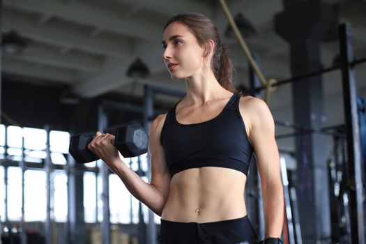 Muscular fit woman exercising building muscles at gym.