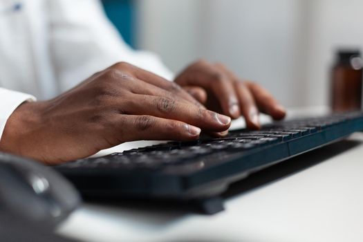 Closeup of african american therapist doctor typing medical expertise