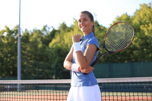 Woman tennis player showing yes gesture after winning point, successful game.