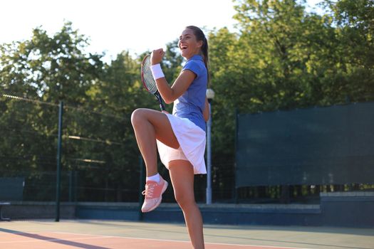 Woman tennis player showing yes gesture after winning point, successful game.