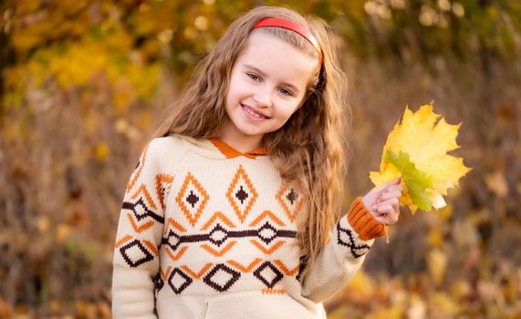 Nice girl holding autumn leaves