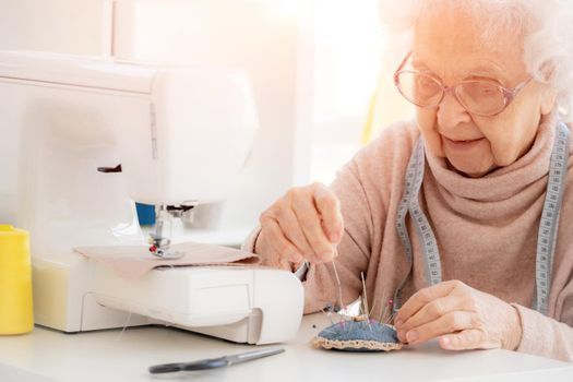 Lovely aged woman sewing
