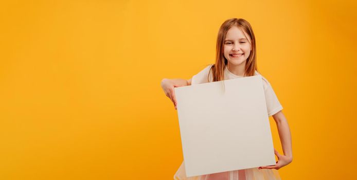 Girl with canvas isolated on yellow background