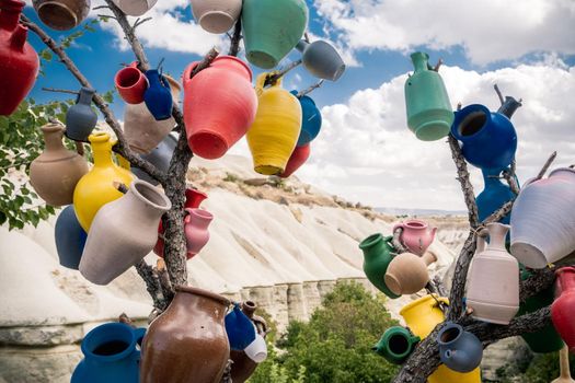 Colorful vases hanging on tree branch