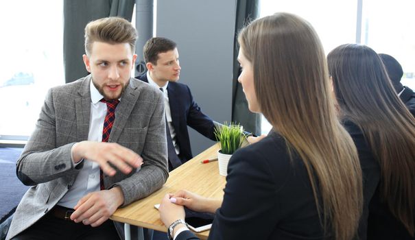 Image of two young business people interacting at meeting in office
