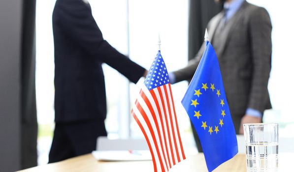 European Union and American leaders shaking hands on a deal agreement.
