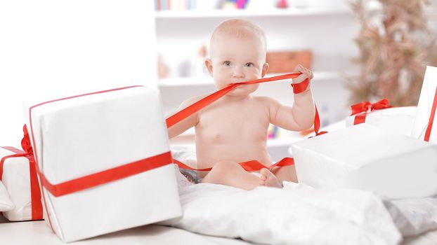 Infant child baby toddler kid sitting in presents gift for celebration. Christmas new year concept.
