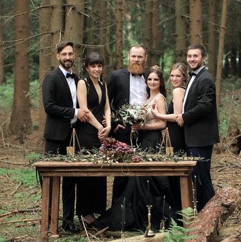 guests and a couple of newlyweds near the picnic table in the woods