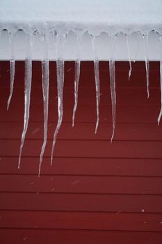 icicles on the roof of a red house in Norway