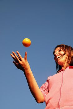 girl balancing orange in air