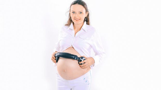happy pregnant woman puts headphones on her tummy