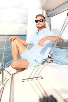 relaxing man sitting on boat sailing on sea happy and carefree.