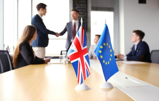 European Union and United Kingdom leaders shaking hands on a deal agreement.