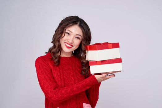 Asian woman in red warm clothes with gifts. Holidays New Year and Christmas.