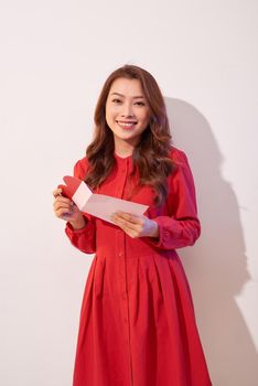 Happy female enjoying greeting card, reading with pleasure love letter, celebrate Valentine day at home