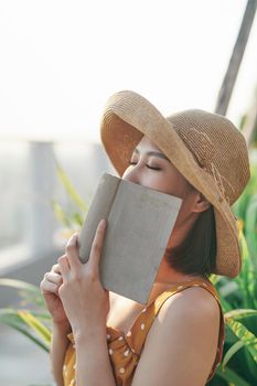 Beautiful girl covering her face with book