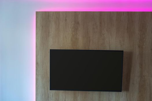 THE TV is mounted on a wall made of wooden panel. Modern interior