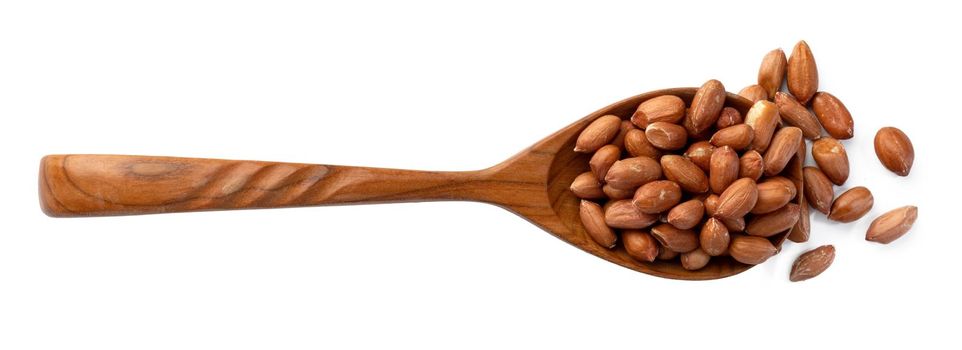 Spoon with peanuts isolated on white background