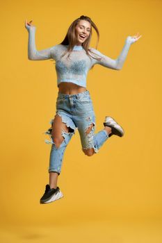 Cheerful girl in jump raising leg up