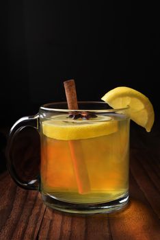 Closeup of a Hot Toody on a dark wood table. The whiskey, lemon and honey drink is often use to help relieve cold and flu symptoms.