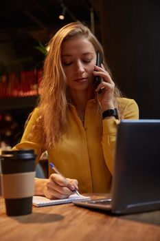 young well dressed cauasian woman sitting at coffee shop, calling by smartphone
