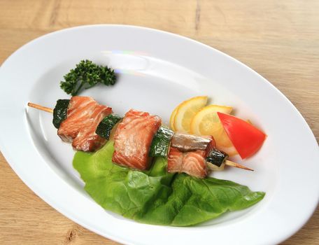 skewers of salmon with garnish on white plate