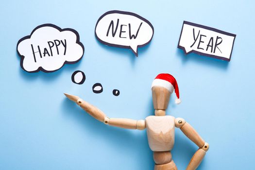 Happy New Year. Wooden puppet doll over blue background