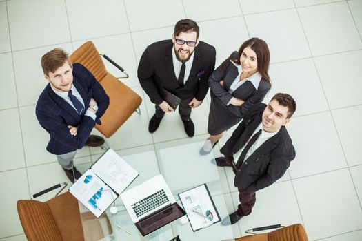 professional business team looking up standing near desktop