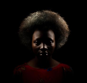 Dark portrait of young black woman with afro hair