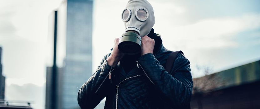 young man wearing a gas mask on a city street