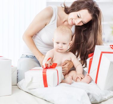 happy mothers her infant baby consider holiday shopping, folded on the sofa in the room