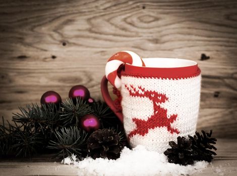 Christmas mug with Christmas decorations in wooden background