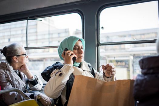 Muslim woman riding public transport in city