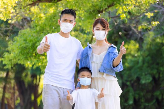 Happy family wearing medical masks to protection and showing thumbs up