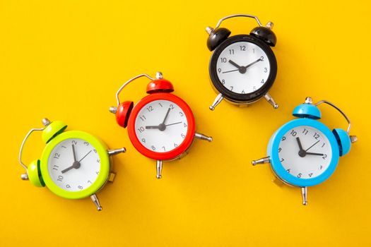 Alarm clock on yellow background.