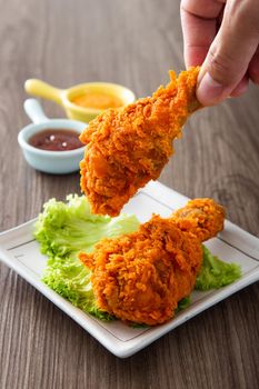 hand holding crispy and golden fried chickens
