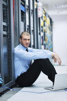 businessman with laptop in network server room