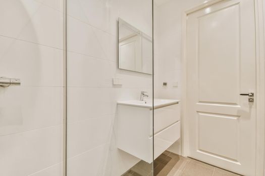 Bathroom interior with hanging chest of drawers and shower cubicle