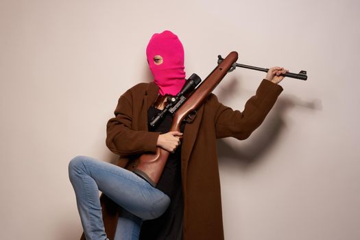 woman gangster with a gun in hand Lifestyle beige background