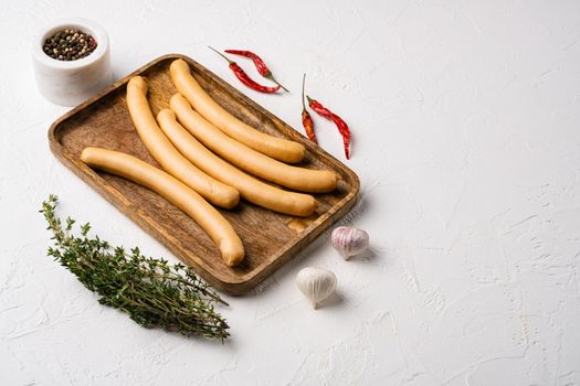 Raw frankfurter sausages, on white stone table background, with copy space for text