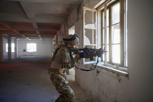 soldier in action near window changing magazine and take cover