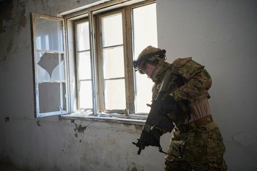 soldier in action near window changing magazine and take cover